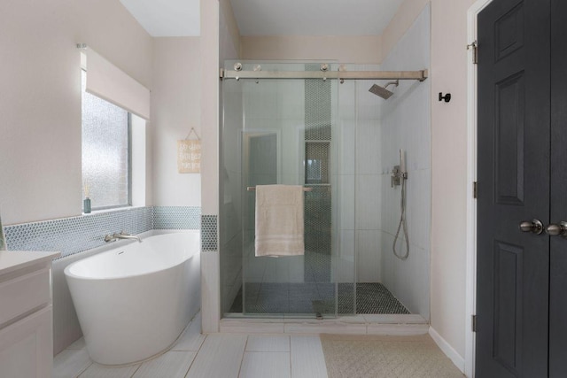 bathroom with a freestanding tub, a shower stall, and tile patterned floors