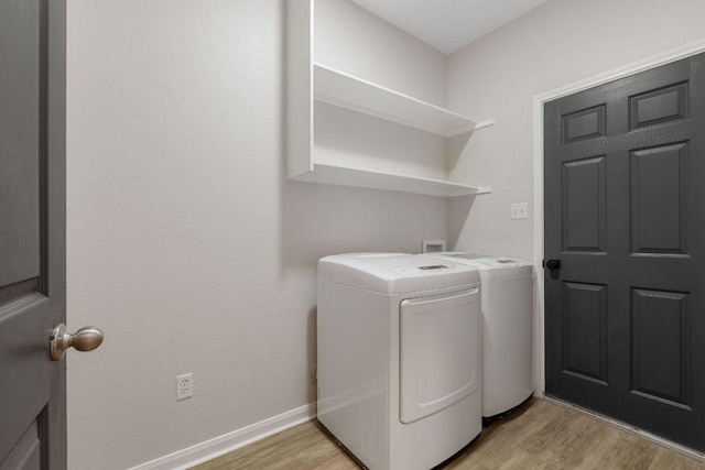 laundry room with washer and dryer, laundry area, baseboards, and light wood finished floors