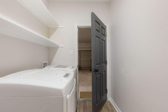 laundry room featuring laundry area, washer and clothes dryer, light wood-style flooring, and baseboards