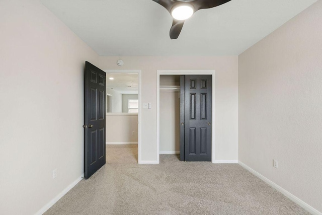 unfurnished bedroom with ceiling fan, baseboards, a closet, and light colored carpet