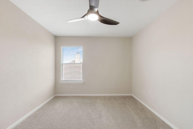 spare room featuring ceiling fan, baseboards, and light colored carpet