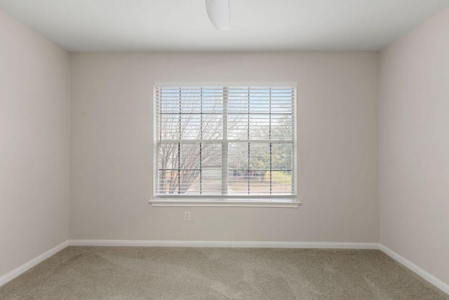 carpeted spare room featuring baseboards