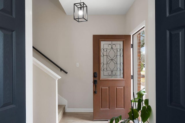 entryway with stairs, baseboards, and wood finished floors