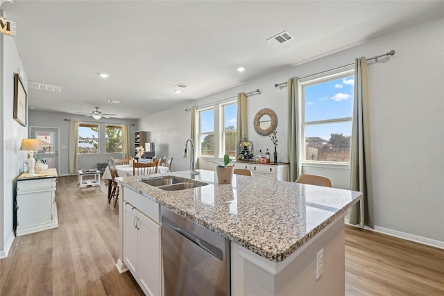 104 Canis St, Georgetown, TX 78628 - kitchen featuring a sink, dishwasher, light wood-style floors, an island with sink, and white cabinets