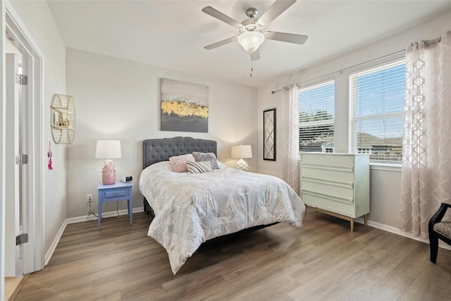 bedroom with light wood-style flooring, baseboards, and ceiling fan