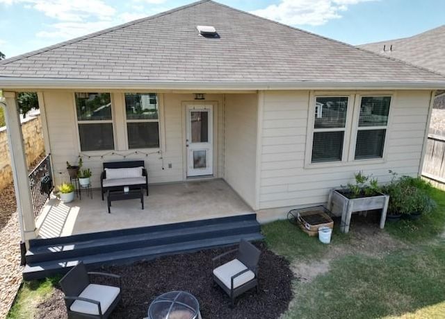 rear view of property featuring fence, a wooden deck, and a shingled roof