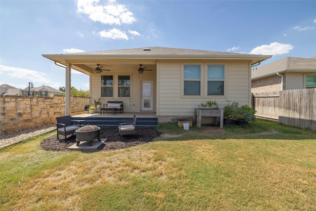 rear view of house featuring an outdoor fire pit, a fenced backyard, a ceiling fan, and a yard