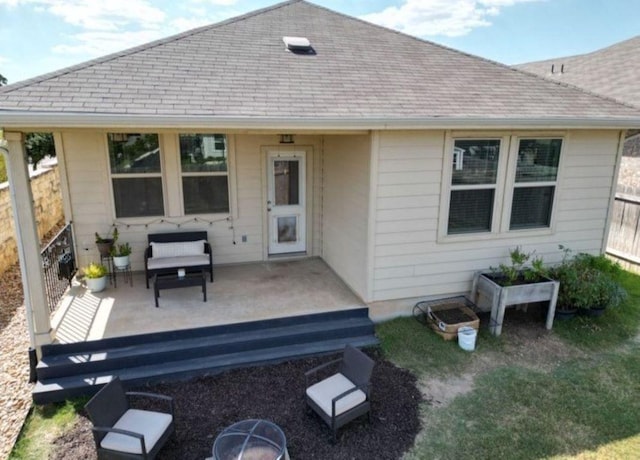 rear view of house featuring a wooden deck, a shingled roof, and fence
