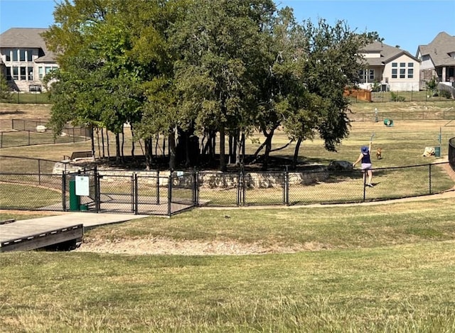 view of community featuring a yard and fence