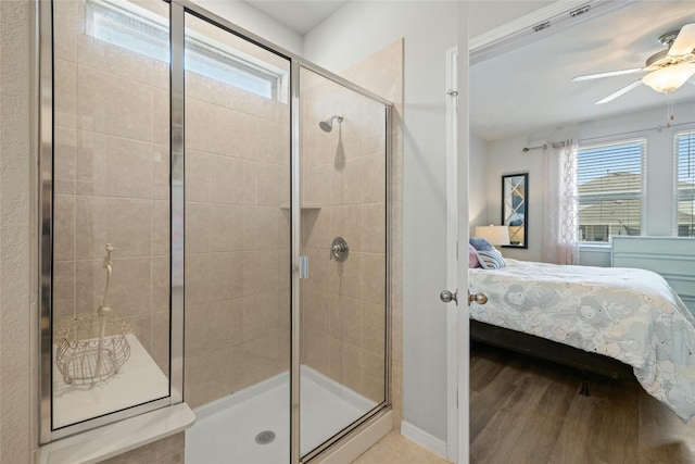 bathroom featuring a ceiling fan, wood finished floors, a stall shower, connected bathroom, and baseboards