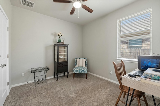 carpeted home office featuring baseboards, visible vents, and a ceiling fan