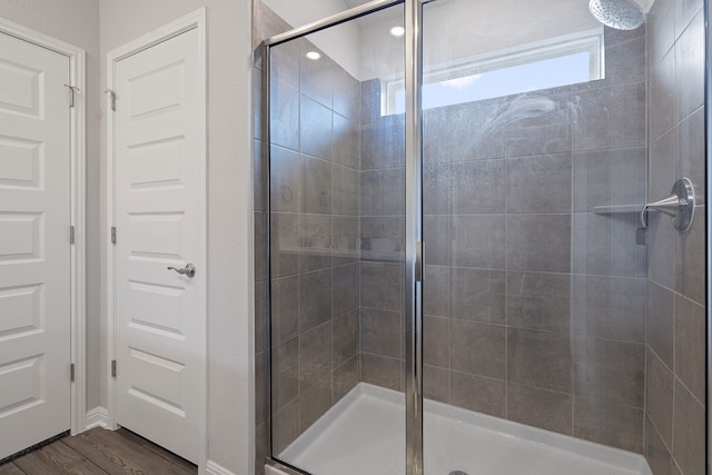 full bath with wood finished floors and a shower stall