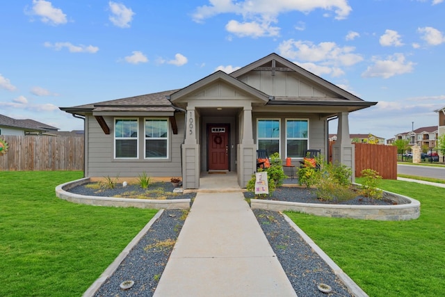 view of front of property with fence, a front lawn, and board and batten siding