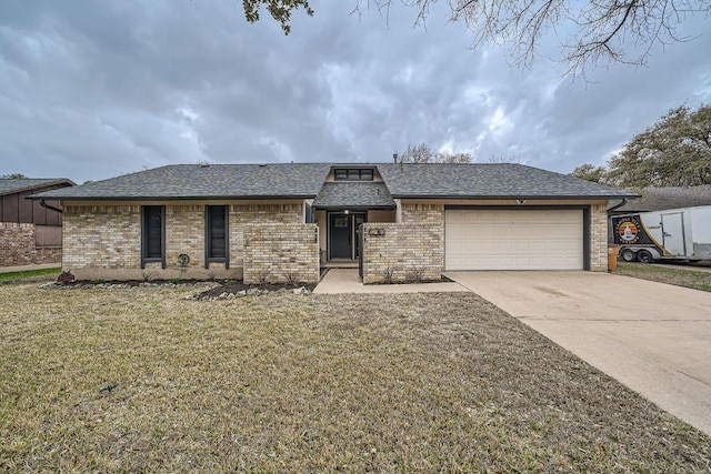 view of front of house featuring a garage, driveway, brick siding, and a front yard