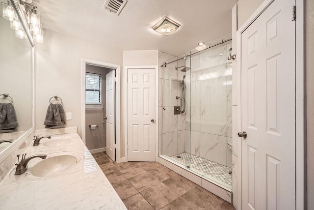 bathroom featuring a stall shower, a sink, and visible vents