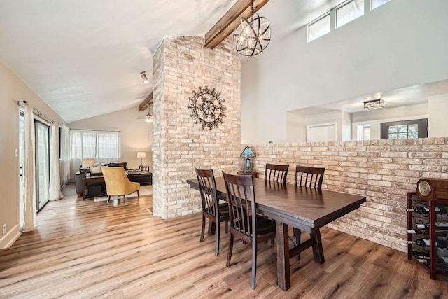 dining room with high vaulted ceiling, plenty of natural light, beamed ceiling, and wood finished floors