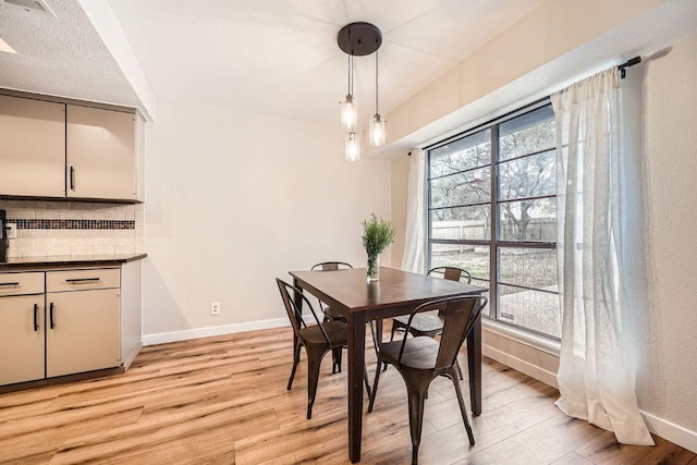 dining area with light wood-style flooring and baseboards