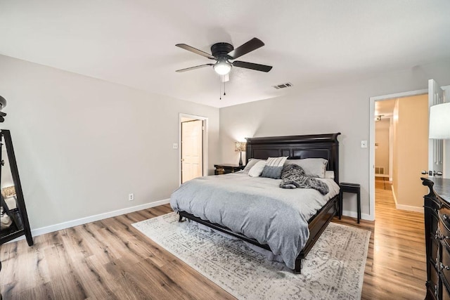 bedroom featuring light wood-type flooring, visible vents, and baseboards