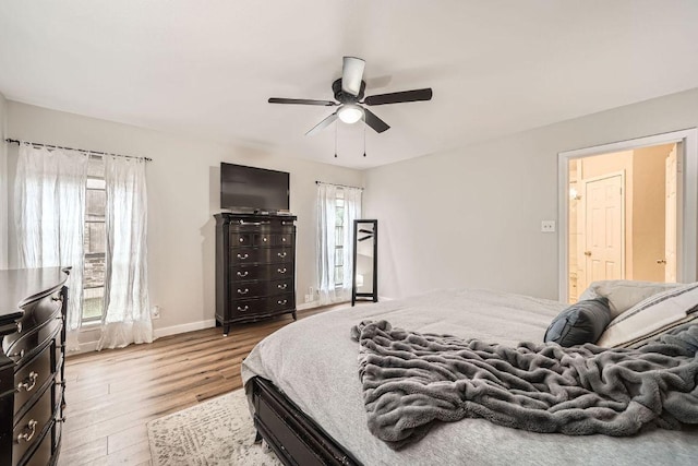 bedroom featuring multiple windows, ceiling fan, baseboards, and wood finished floors