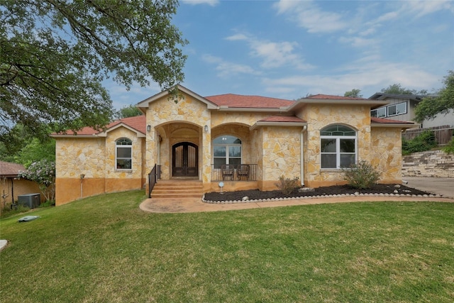 mediterranean / spanish-style house featuring a front yard, french doors, and central AC unit