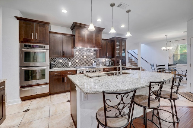 kitchen featuring a sink, visible vents, appliances with stainless steel finishes, a warming drawer, and tasteful backsplash