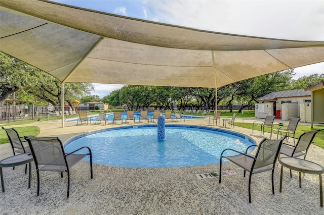 community pool with fence and a patio