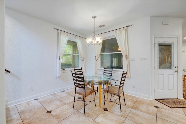 dining room with light tile patterned floors, baseboards, visible vents, and a notable chandelier