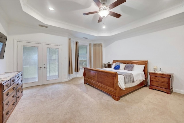 bedroom with light carpet, ornamental molding, access to outside, a tray ceiling, and french doors