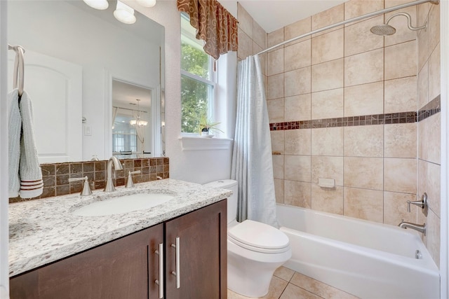 bathroom featuring toilet, tile patterned flooring, shower / bathtub combination with curtain, vanity, and a notable chandelier