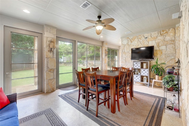 dining room featuring a sunroom, ceiling fan, visible vents, and speckled floor