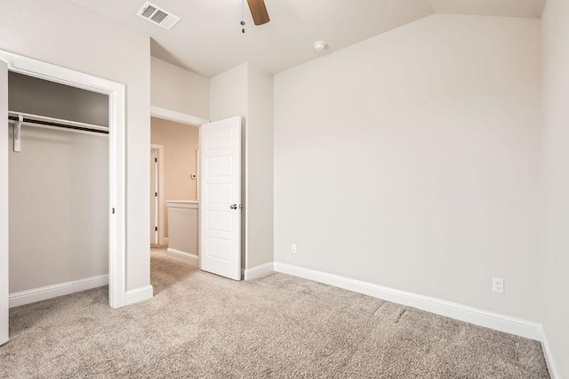 unfurnished bedroom with baseboards, visible vents, vaulted ceiling, carpet floors, and a closet