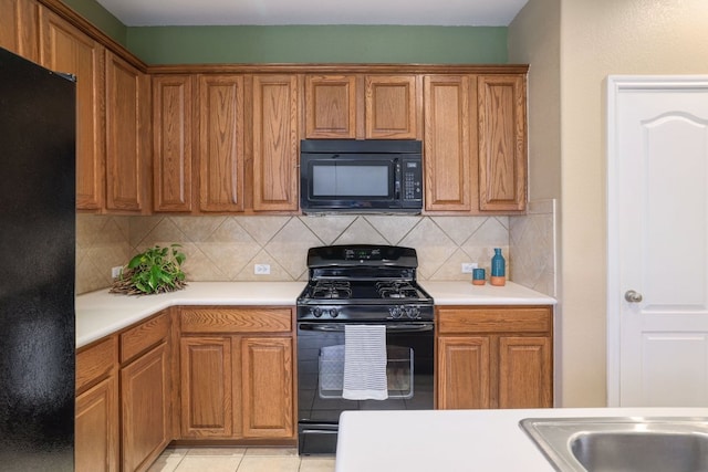 2000 Amur Dr, Austin, TX 78745 - kitchen with black appliances, brown cabinets, decorative backsplash, and light countertops