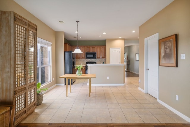 2000 Amur Dr, Austin, TX 78745 - kitchen with black appliances, tasteful backsplash, light tile patterned flooring, pendant lighting, and brown cabinetry