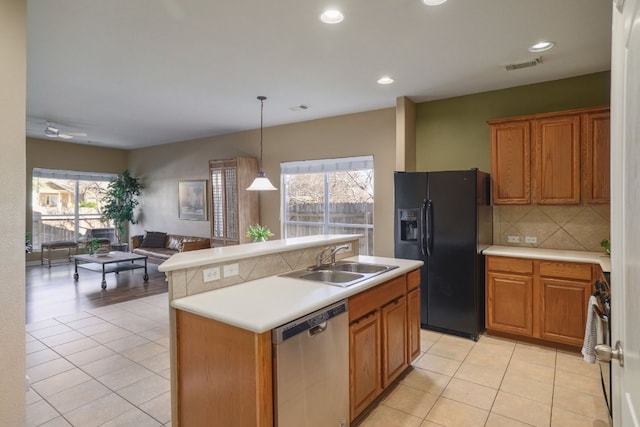 2000 Amur Dr, Austin, TX 78745 - kitchen with stainless steel dishwasher, black refrigerator with ice dispenser, open floor plan, light tile patterned floors, and recessed lighting