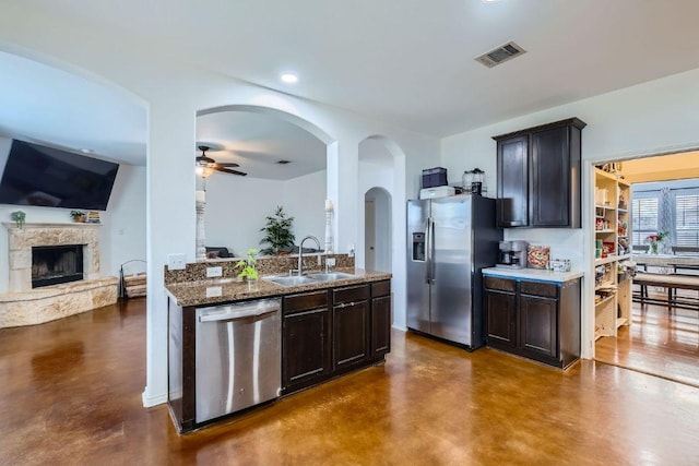 2141 Dragon Trl, New Braunfels, TX 78130 - kitchen featuring appliances with stainless steel finishes, concrete floors, a stone fireplace, a ceiling fan, and recessed lighting