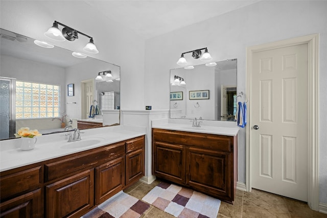 bathroom with two vanities, a sink, and a shower with door