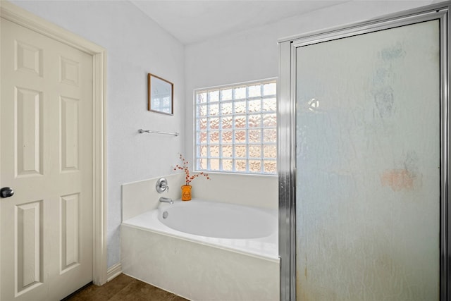 bathroom featuring a garden tub and a shower stall