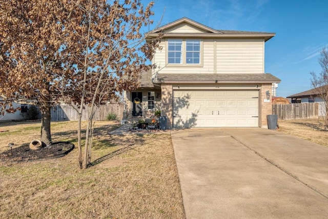 traditional-style house featuring concrete driveway, an attached garage, fence, a front yard, and brick siding