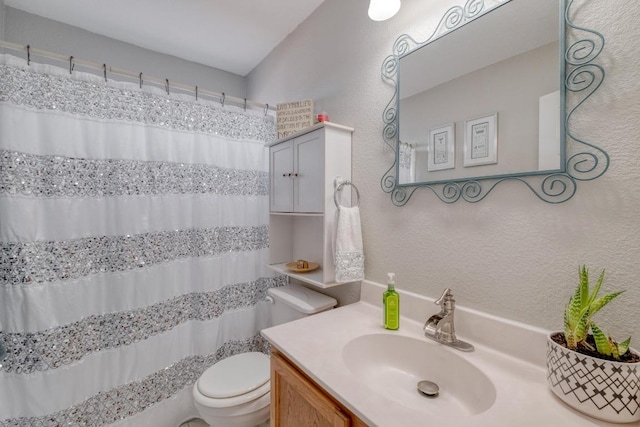 bathroom with toilet, vanity, a shower with shower curtain, and a textured wall