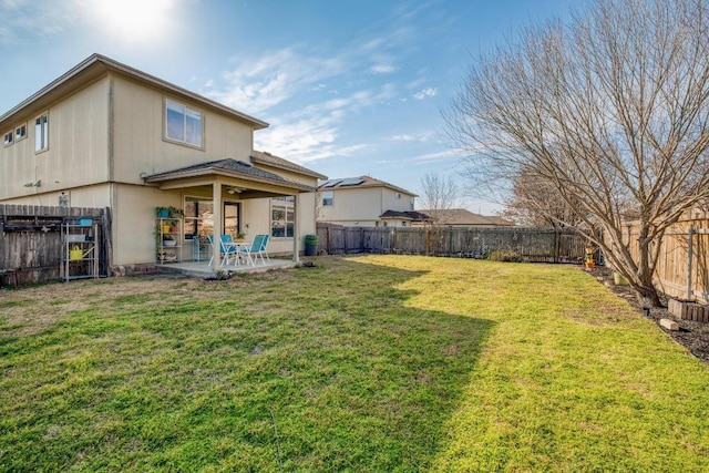 back of house featuring a patio area, a fenced backyard, and a lawn