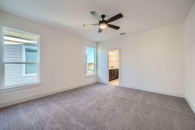 unfurnished bedroom featuring visible vents, baseboards, a ceiling fan, connected bathroom, and light colored carpet