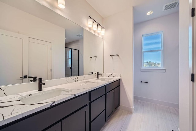 bathroom with a stall shower, visible vents, a sink, and double vanity