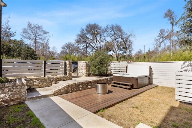 view of yard featuring a hot tub, fence, and a wooden deck