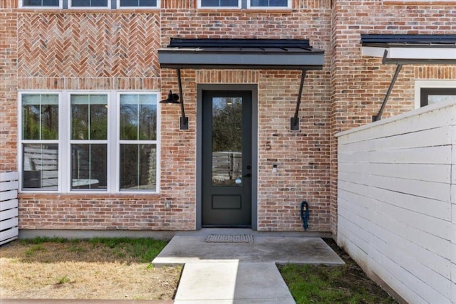 entrance to property featuring brick siding