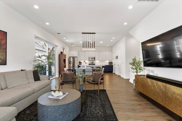 living room featuring wood finished floors, visible vents, and recessed lighting