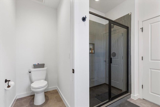 full bath featuring tile patterned flooring, baseboards, a shower stall, and toilet