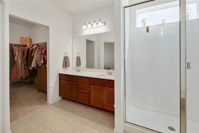 bathroom with a sink, a walk in closet, and a shower stall