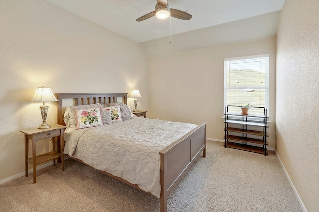 bedroom with a textured wall, light colored carpet, vaulted ceiling, and baseboards