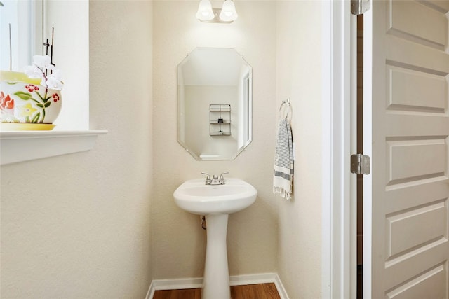 bathroom with baseboards and wood finished floors