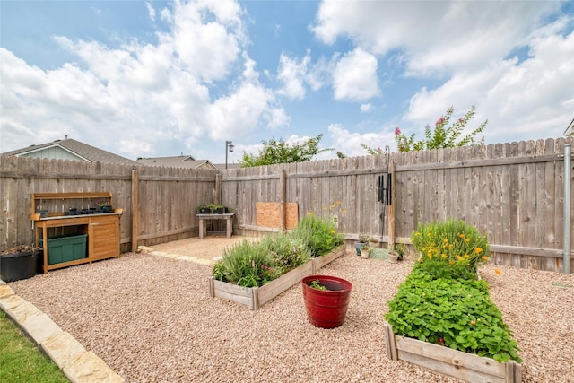 view of yard with a fenced backyard and a garden